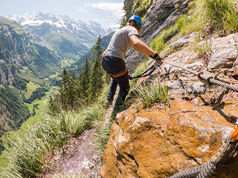 运动男子在Via Ferrata攀登，夏季活动的概念